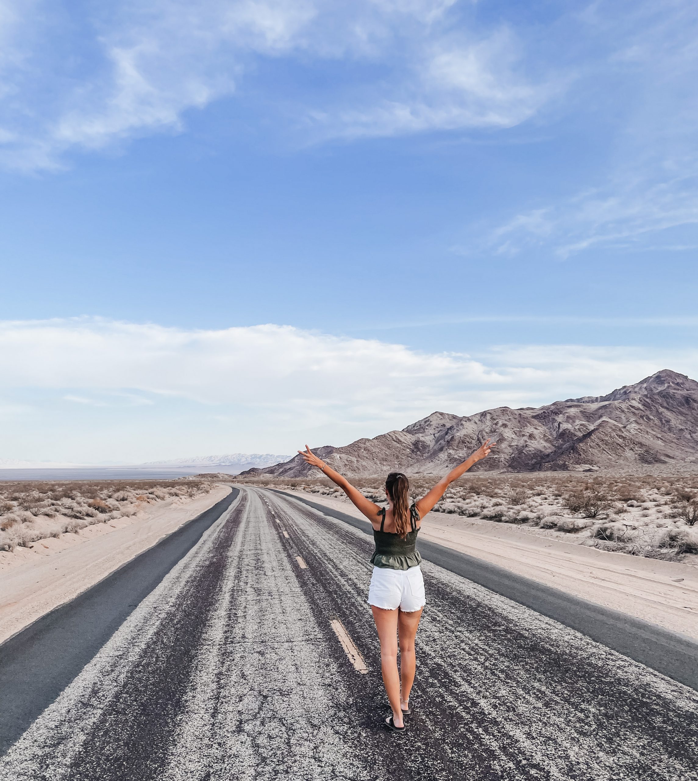 Ansicht von hinten auf mich, Lisa-Marie, der auf einer Straße steht und in die Ferne blickt als Sinnbild für den Ziel der Ayurveda Beratung